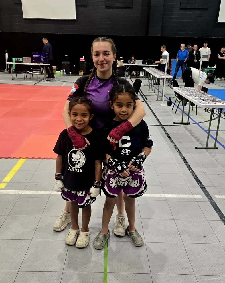 A TCB coach and young martial artists at competition