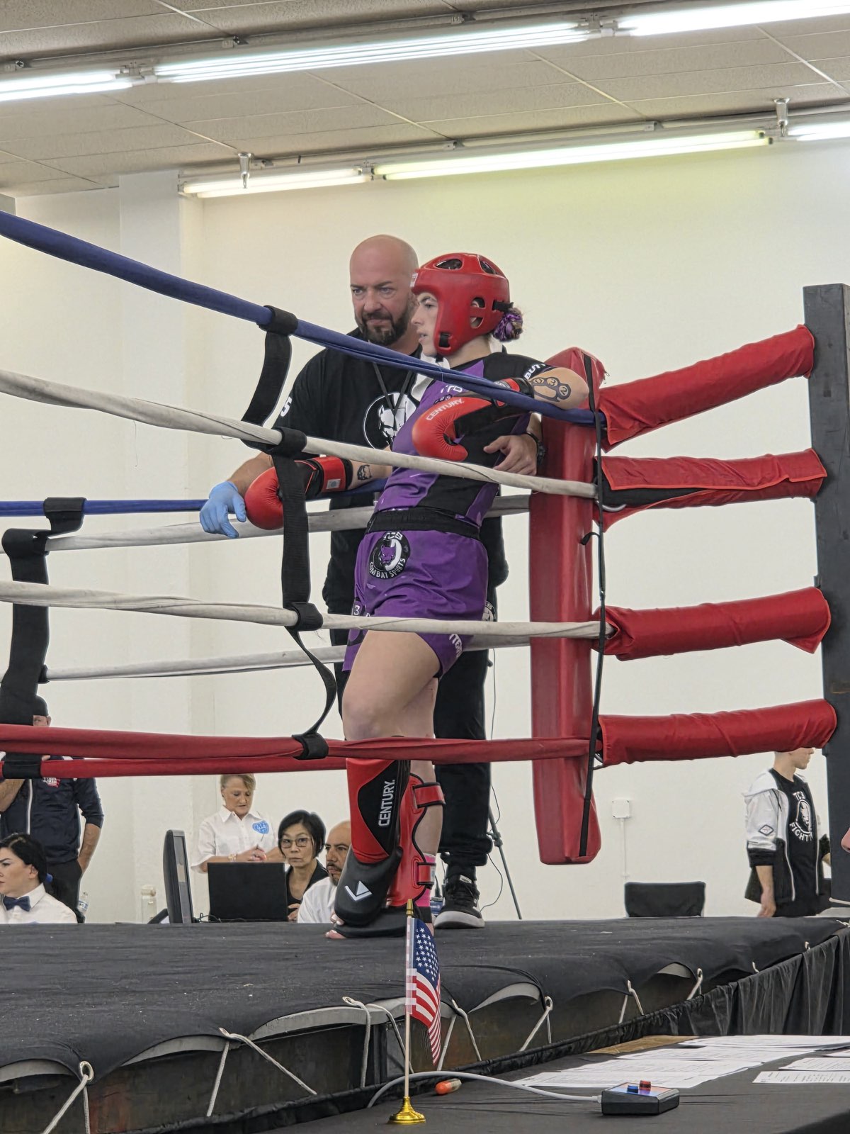 Papa Pit cornering a TCB female fighter in red headgear and purple shorts in the ring at the 2026 WAKO USA Nationals