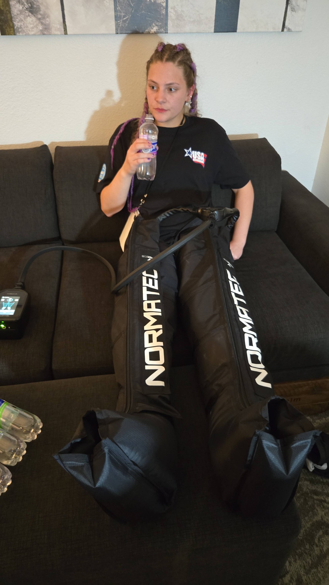 TCB female fighter in USA Boxing tee using NormaTec recovery boots between bouts at the 2026 WAKO USA Nationals