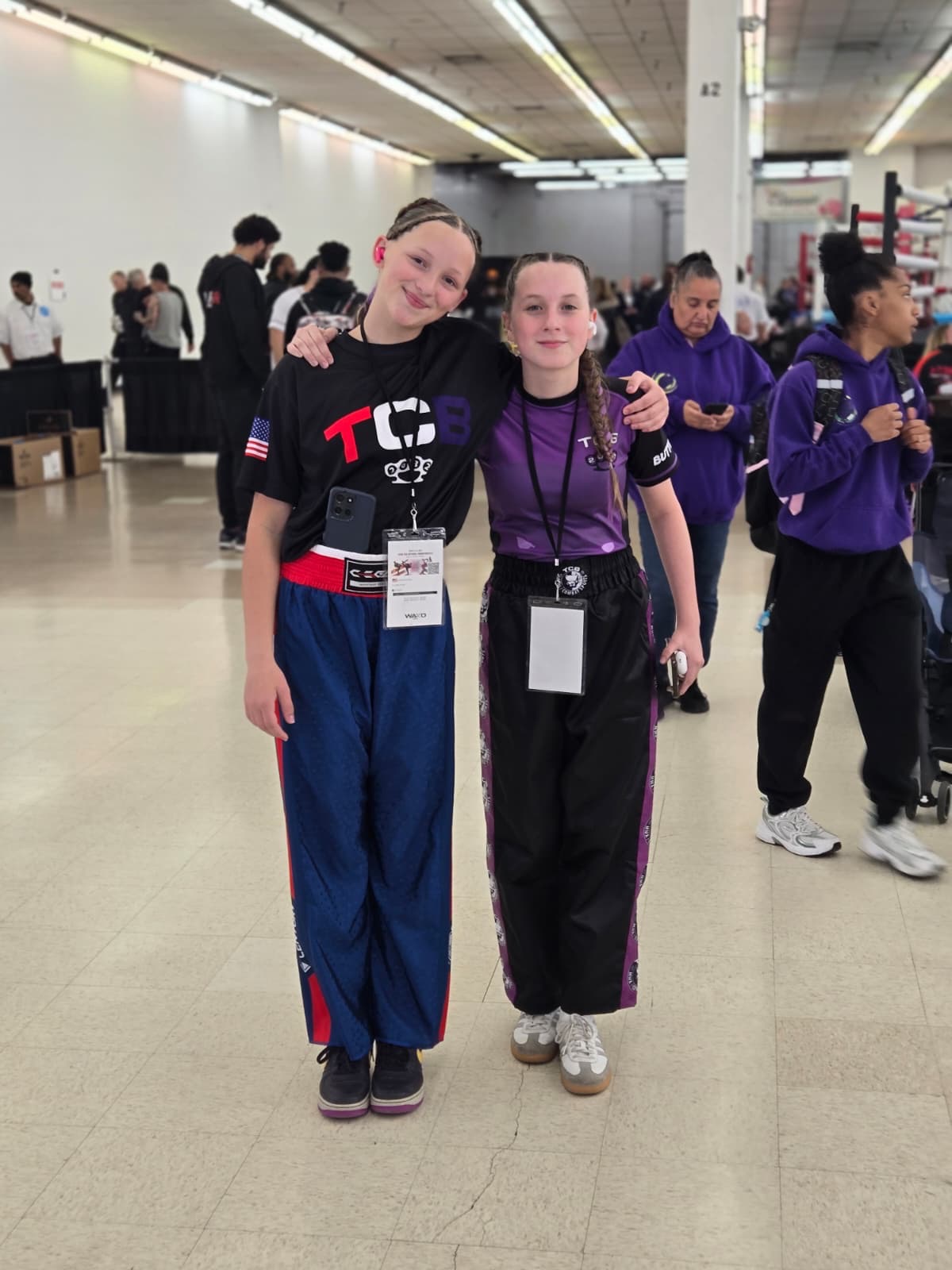 Two TCB youth female fighters in matching team gear with WAKO tournament credentials at the 2026 WAKO USA Nationals